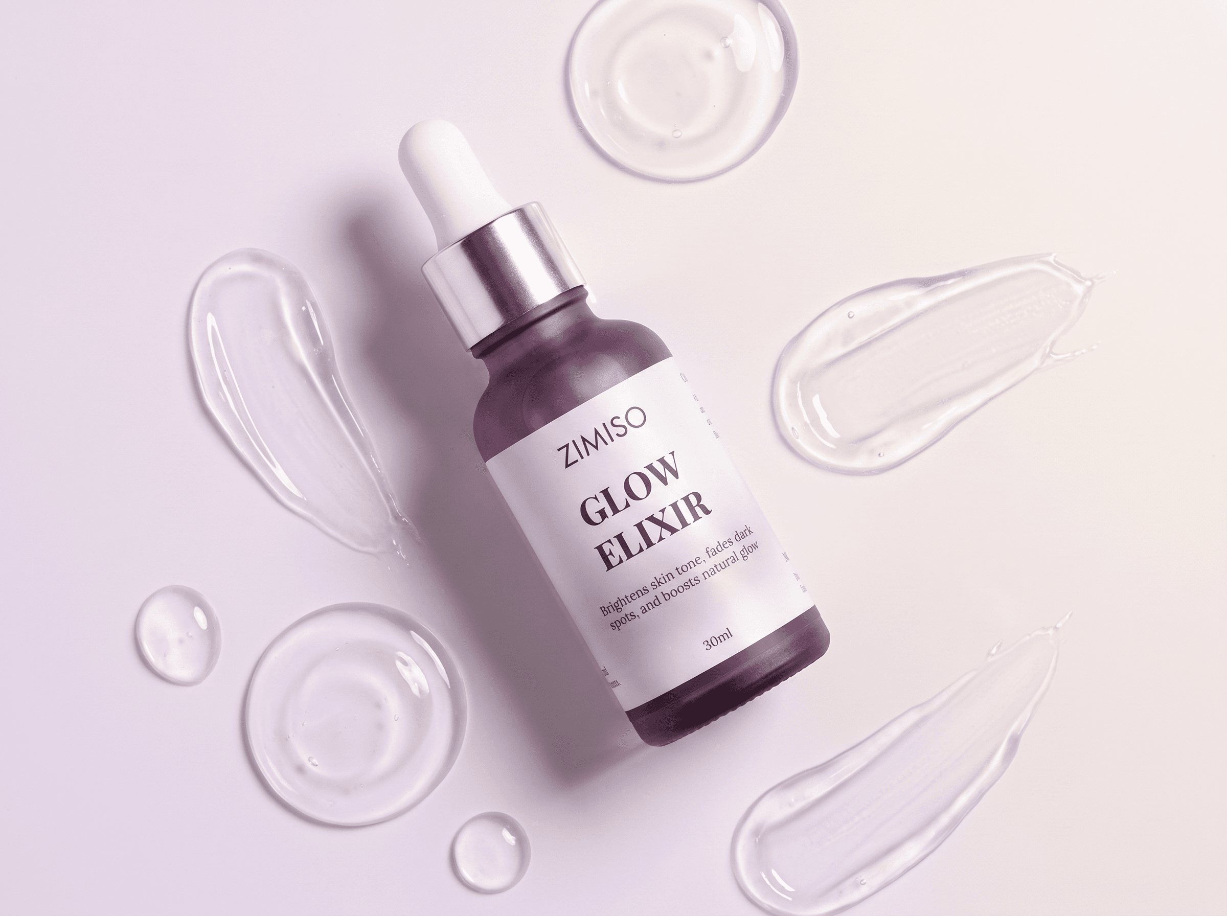 Overhead flat lay of the ZIMISO Glow Elixir surrounded by clear serum swatches